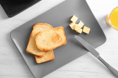 Ahşap masa üzerinde lezzetli kızarmış ekmek ve tereyağı ile plaka