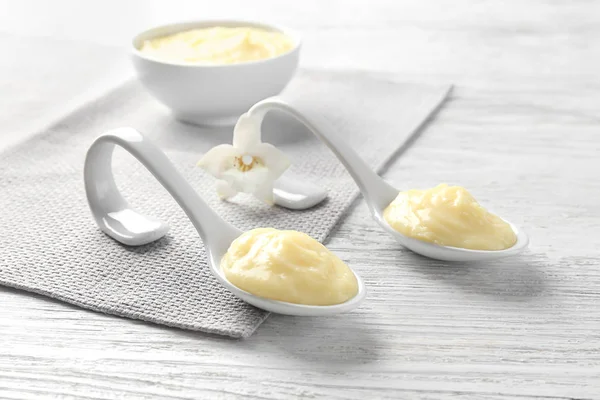 Ceramic spoons with vanilla pudding on table — Stock Photo, Image
