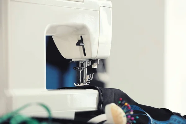 Швейная машина с тканями на столе — стоковое фото