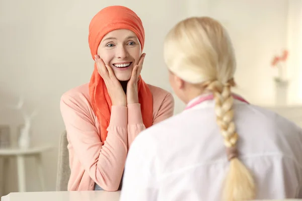 Ung kvinna med cancer gästande läkare på sjukhus — Stockfoto