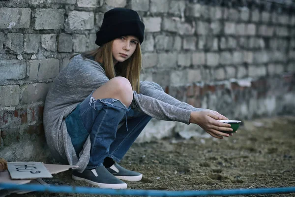 Homeless poor teenage girl holding empty bowl outdoors — Stock Photo, Image