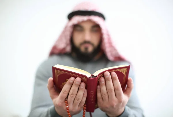 Jovem muçulmano lendo Alcorão no fundo claro — Fotografia de Stock