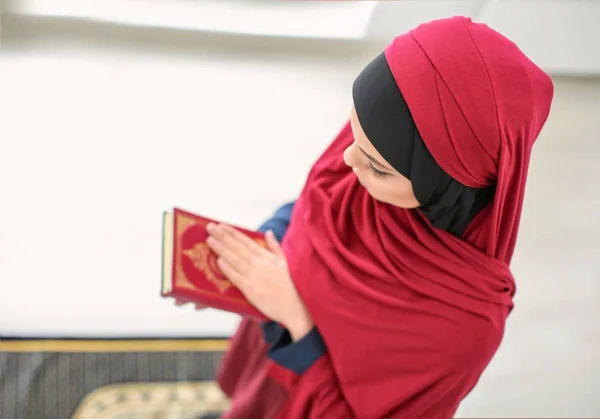 Jonge Moslimvrouw Holding Van Koran Bidden Binnenshuis — Stockfoto