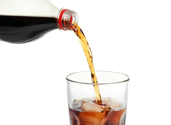 Cola menuangkan dari botol ke gelas dengan es di latar belakang putih — Stok Foto