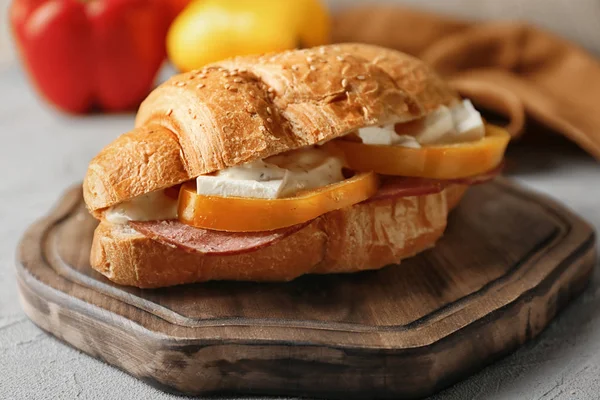 Tasty croissant sandwich on wooden board — Stock Photo, Image