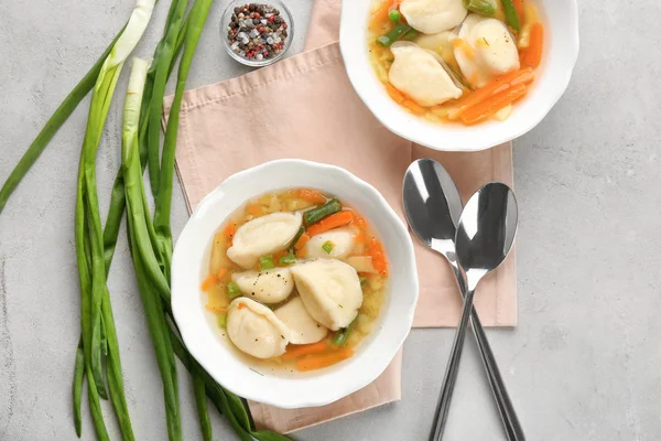 Tasty broth with dumplings on table — Stock Photo, Image