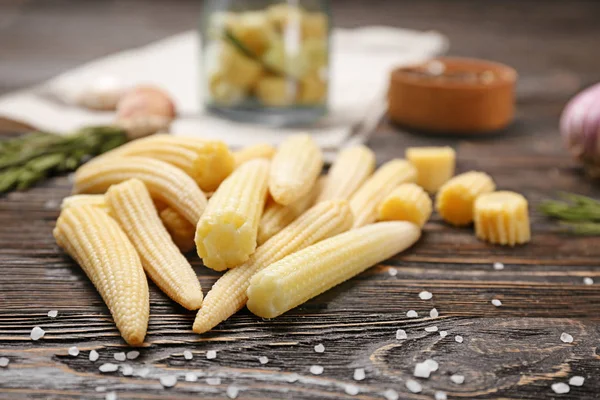 Heap of fresh young baby corn on wooden table — Stock Photo, Image
