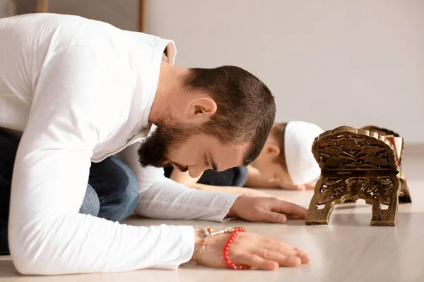 Μουσουλμανική πατέρας και γιος που προσεύχεται μαζί, σε εσωτερικούς χώρους — Φωτογραφία Αρχείου