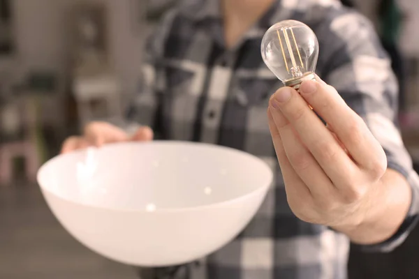 Homme changeant ampoule dans la lampe à la maison — Photo