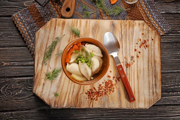Kom met smakelijke bouillon en knoedels op tafel — Stockfoto