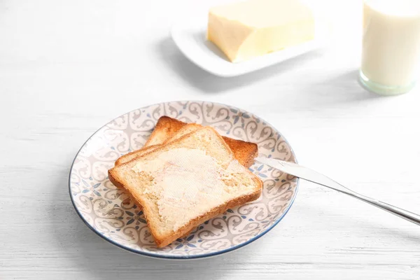 Pain grillé savoureux avec du beurre sur l'assiette — Photo