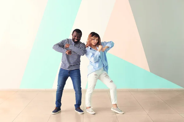 Linda pareja interracial bailando contra la pared de color — Foto de Stock