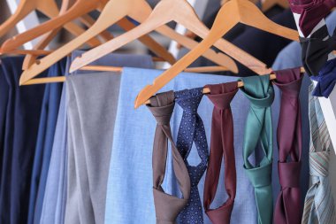 Hangers with suits and ties in tailor's workshop clipart