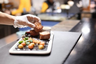 Şef lezzetli hazırlama sunumu restoranda domuz eti ve sebze salsa sarılı Somon ızgara