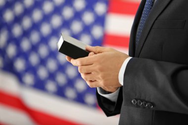 İncil'de ve Amerikan bayrağı arka planda tutan adam