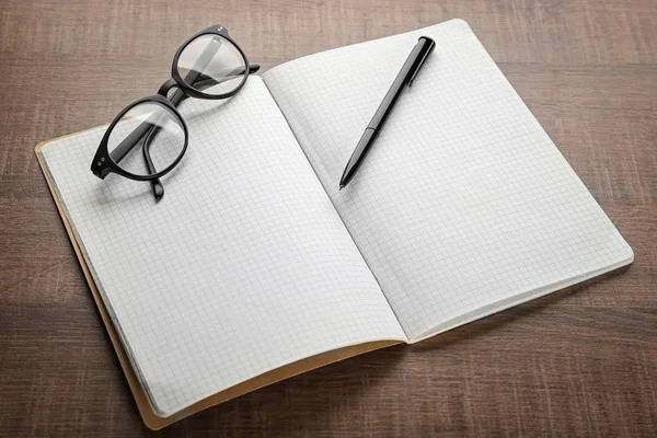 Caderno e óculos na mesa — Fotografia de Stock