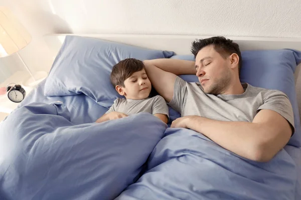 Pai com filho dormindo na cama em casa — Fotografia de Stock