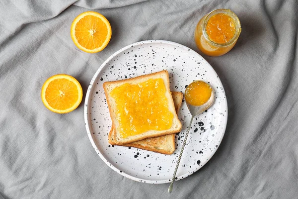 Delicious toast with sweet jam on plate, top view — Stock Photo, Image