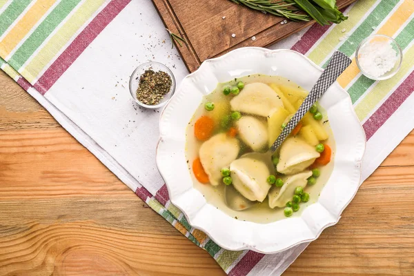 Piatto con brodo saporito e gnocchi sul tavolo — Foto Stock