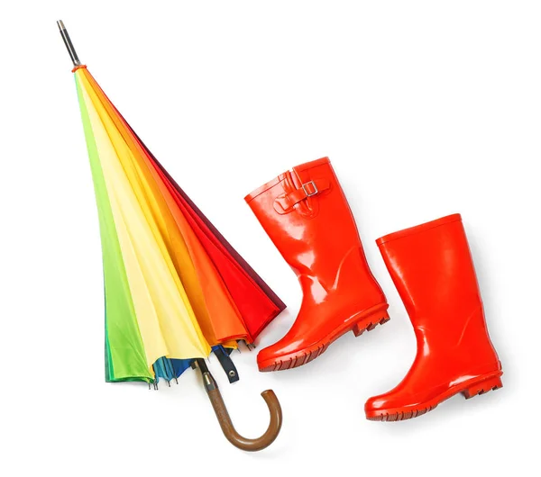 Ombrello arcobaleno con stivali di gomma su sfondo bianco — Foto Stock