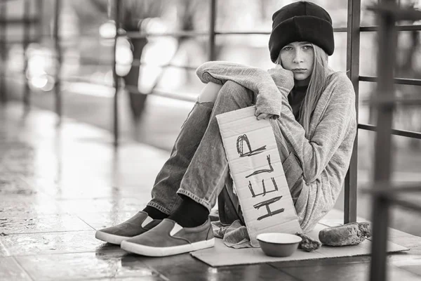 无家可归的可怜的少女拿着一块纸板与 word 帮助户外 — 图库照片