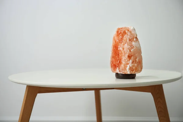 Lámpara de sal del Himalaya sobre mesa sobre fondo claro —  Fotos de Stock