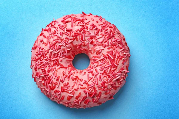 Delicioso donut rosa no fundo da cor — Fotografia de Stock