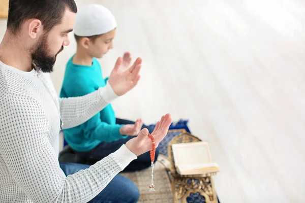 Μουσουλμανική πατέρας και γιος που προσεύχεται μαζί, σε εσωτερικούς χώρους — Φωτογραφία Αρχείου