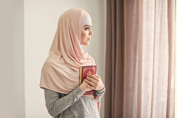 Młoda Muzułmanka Gospodarstwa Koranu Modląc Się Pomieszczeniu — Zdjęcie stockowe