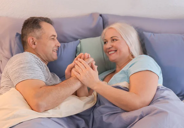 Senior par i seng sammen - Stock-foto