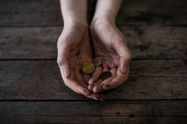 Poor woman with coins on wooden background — Stock Photo, Image