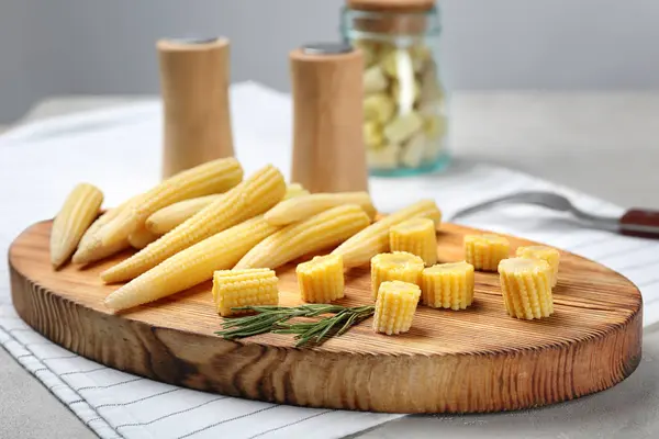 Wooden board with fresh young baby corn on table — Stock Photo, Image