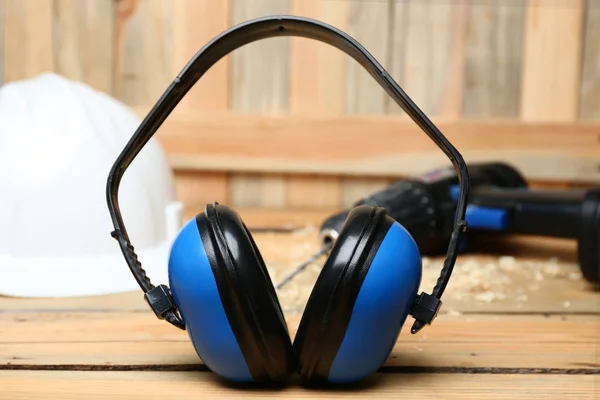 Headphones and hard hat on table. Hearing protection — Stock Photo, Image