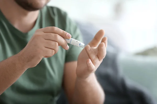 Homem diabético tomando amostra de sangue com caneta lancet em casa, close-up — Fotografia de Stock