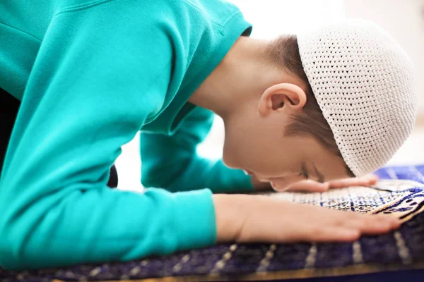 Маленький мусульманский мальчик молится в помещении — стоковое фото