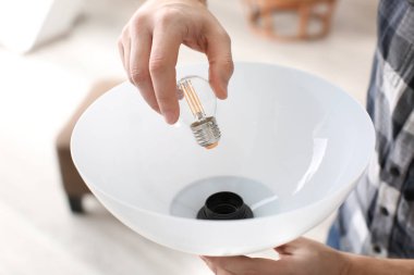 Evdeki ampulü değiştiren adam.