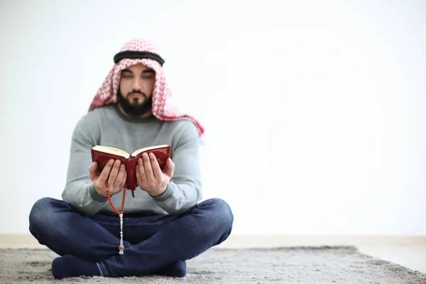 Junger muslimischer Mann liest Koran, drinnen — Stockfoto