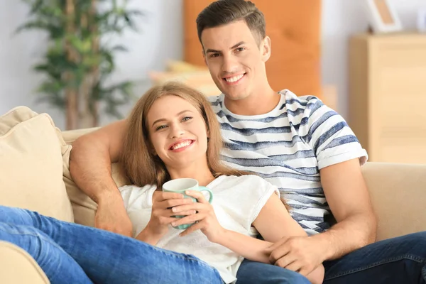 Jeune couple sur canapé à la maison — Photo