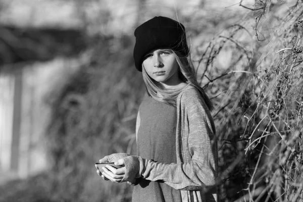 Homeless poor teenage girl holding empty bowl outdoors