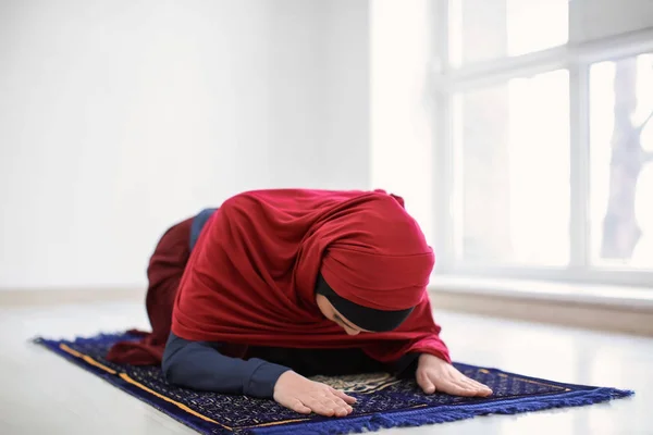 Young Muslim woman praying, indoors