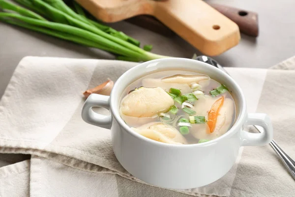 Tasty broth with dumplings on table — Stock Photo, Image