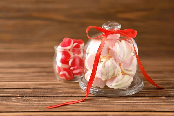 Glassware with marshmallows and candies on wooden background — Stock Photo, Image