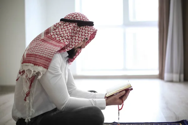 Joven musulmán leyendo el Corán, en interiores — Foto de Stock