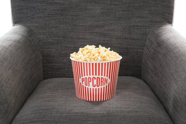 Eimer mit leckerem Popcorn auf Sessel, Nahaufnahme. Heimkino — Stockfoto