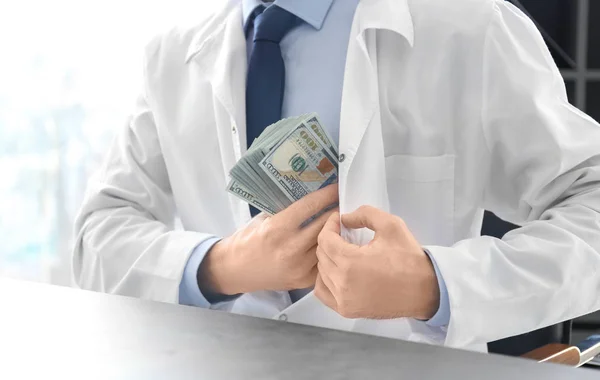 Doktor přijetí úplatku na jeho pracovišti, closeup — Stock fotografie