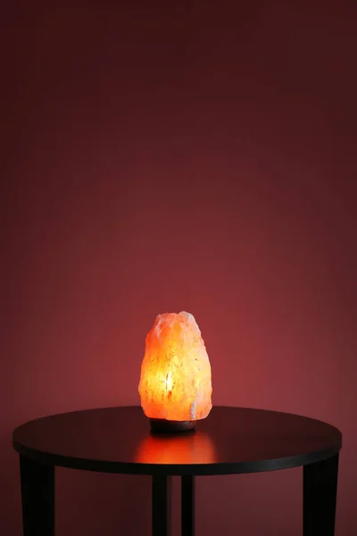 Himalaya zout lamp op tafel tegen een achtergrond met kleur — Stockfoto