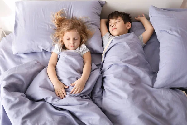 Lindos niños pequeños durmiendo en la cama en casa. Hora de dormir familiar — Foto de Stock