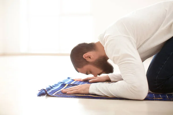 Молодой мусульманин молится в помещении — стоковое фото