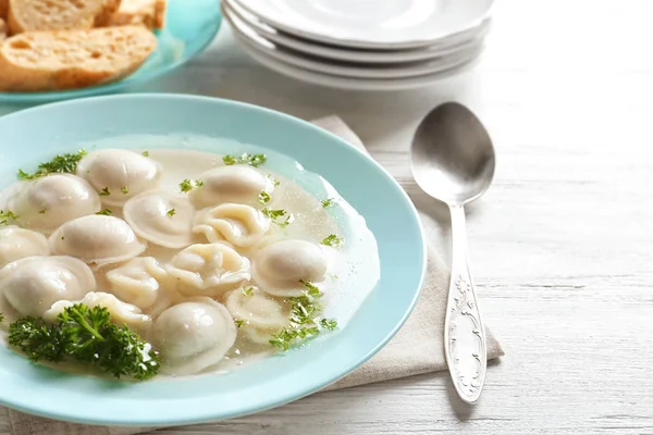 Smakelijk bouillon met knoedels op houten tafel — Stockfoto