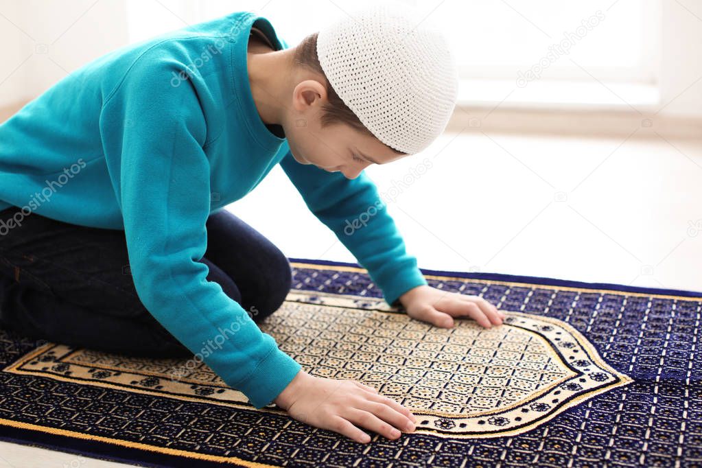 Little Muslim boy praying, indoors